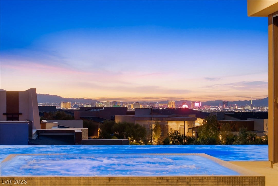 2208 Overlook Canyon Lane, Henderson, NV 89052 City lights sparkle against the horizon, providing a dramatic backdrop for a tranquil pool.