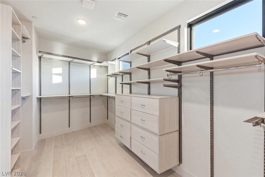 2208 Overlook Canyon Lane, Henderson, NV 89052 Ample storage solutions define this naturally illuminated walk-in closet with integrated shelving and drawers.