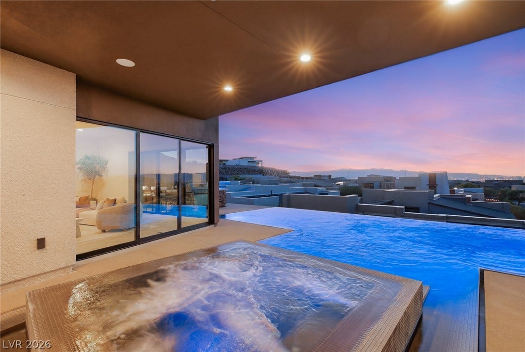 2208 Overlook Canyon Lane, Henderson, NV 89052 An inviting infinity pool and spa offer breathtaking views against a colorful evening sky.