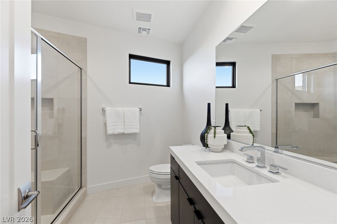 2208 Overlook Canyon Lane, Henderson, NV 89052 A well-appointed bath features a spacious vanity with an undermount sink and a glass-enclosed shower.