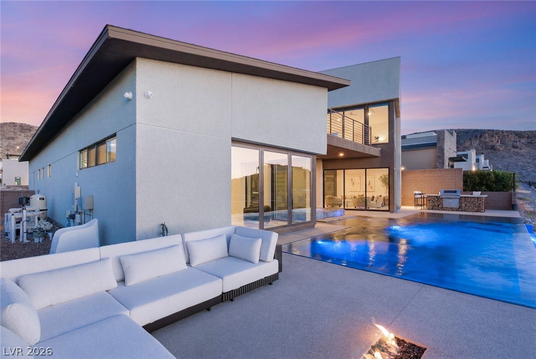 2208 Overlook Canyon Lane, Henderson, NV 89052 An inviting outdoor oasis features a sleek pool with integrated fire features and a sophisticated barbecue area, perfect for entertaining.