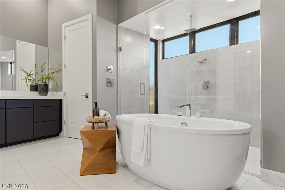 2208 Overlook Canyon Lane, Henderson, NV 89052 A refined primary bath features a freestanding tub and walk-in shower with high windows.