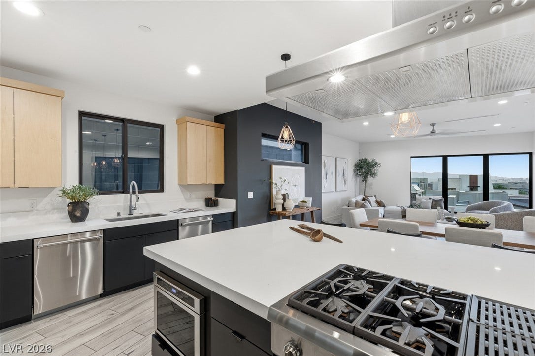 2208 Overlook Canyon Lane, Henderson, NV 89052 An open-concept living space integrates a chef's kitchen with a spacious dining and lounge area, all enjoying abundant natural light and panoramic views.