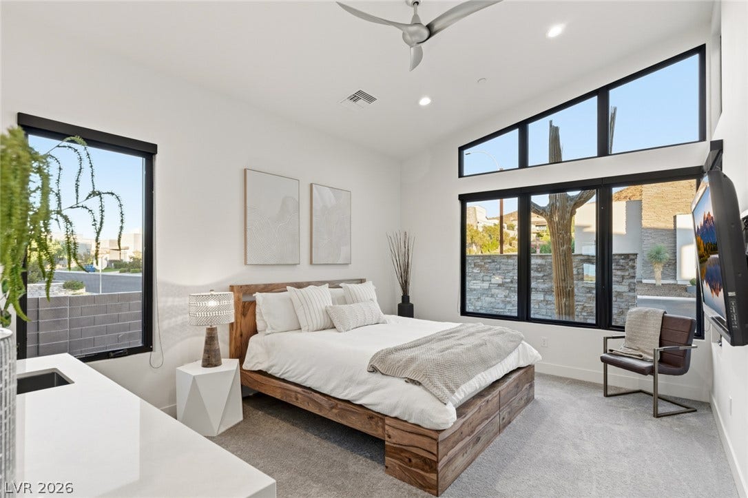 2208 Overlook Canyon Lane, Henderson, NV 89052 Natural light floods this primary bedroom through expansive windows, highlighting the clean design.