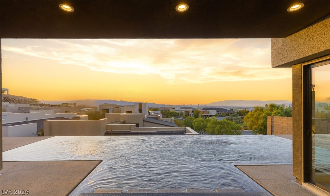 2208 Overlook Canyon Lane, Henderson, NV 89052 An inviting infinity pool overlooking a scenic mountain and city view at sunset.