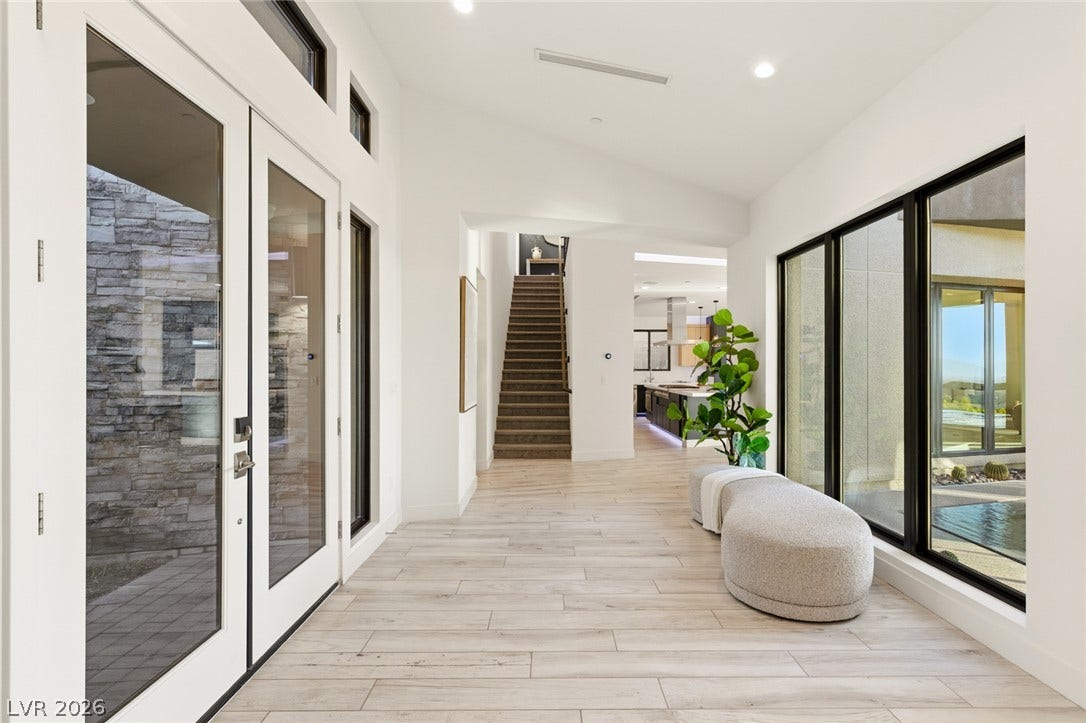 2208 Overlook Canyon Lane, Henderson, NV 89052 A grand entrance with high ceilings, sleek wood flooring, and direct access to outdoor living spaces.