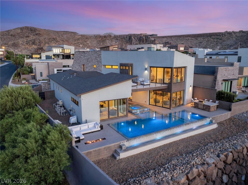 2208 Overlook Canyon Lane, Henderson, NV 89052 An exquisite outdoor living space boasts a luminous pool, relaxing spa, and fire pit, perfect for entertaining.