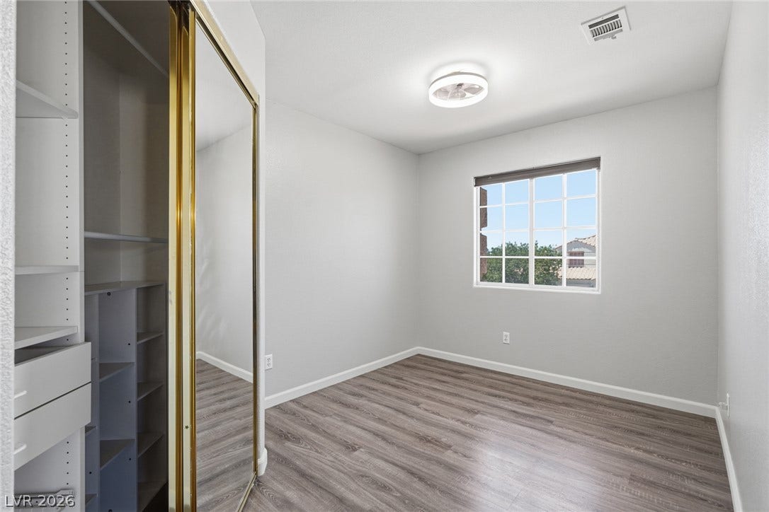 206 Oleander Place, Henderson, NV 89015 A well-lit room with resilient flooring and an integrated closet system provides a versatile living space.