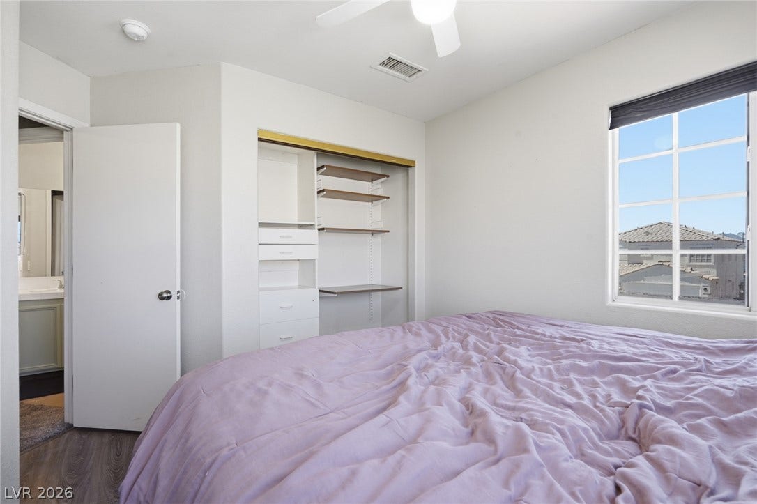 206 Oleander Place, Henderson, NV 89015 A well-lit bedroom with built-in closet organization and ample natural light from the window.