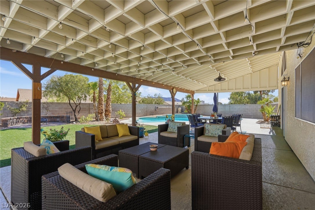 206 Oleander Place, Henderson, NV 89015 An inviting covered patio with string lights overlooks a private yard with a refreshing pool.