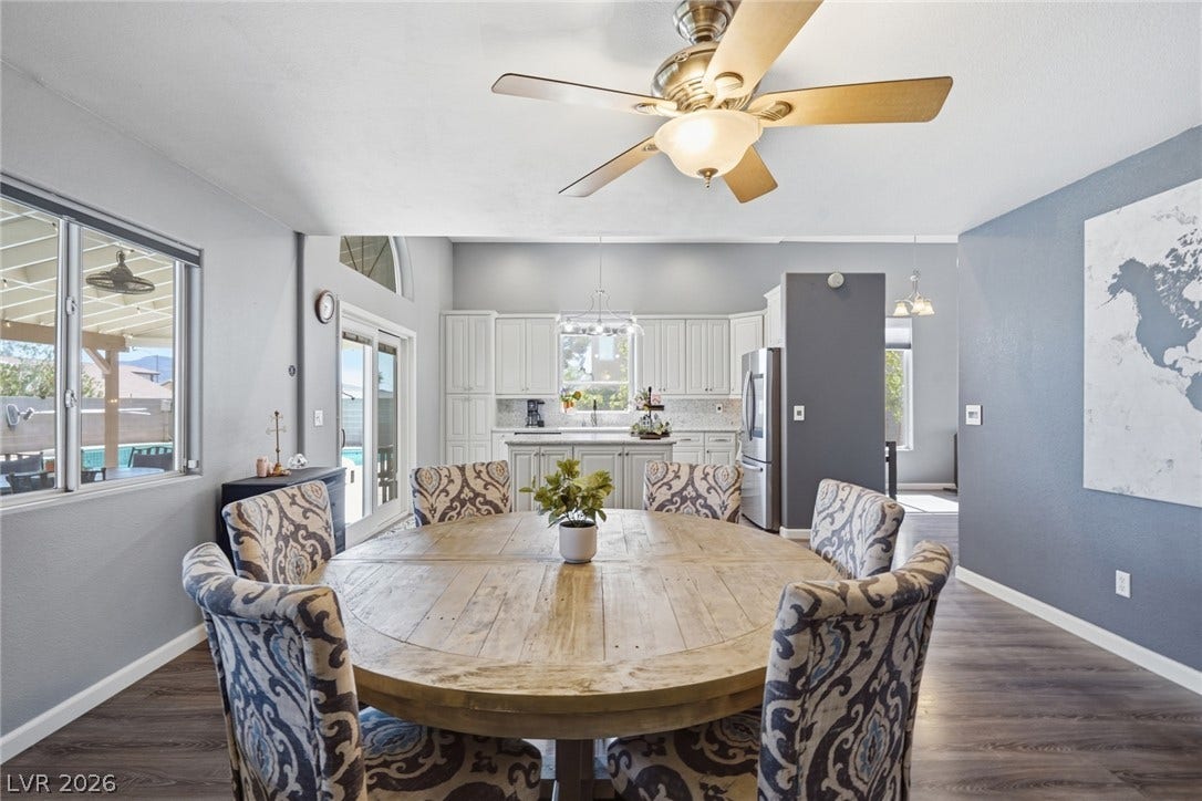 206 Oleander Place, Henderson, NV 89015 Dining area with rich hardwood flooring and a ceiling fan, connecting to a bright kitchen.