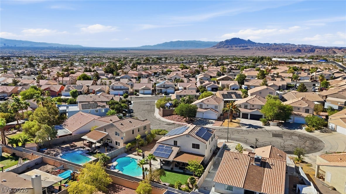 206 Oleander Place, Henderson, NV 89015 An aerial perspective showcases a residential neighborhood with private pools and distant desert mountains.