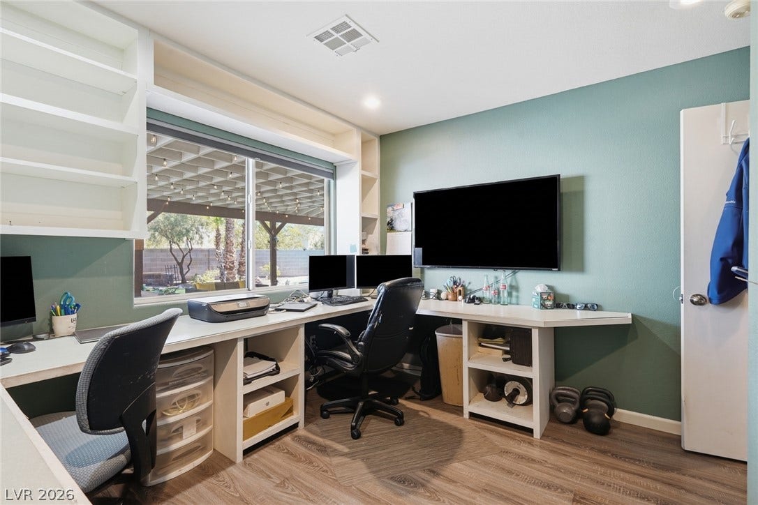 206 Oleander Place, Henderson, NV 89015 A dedicated home office provides ample workspace with built-in shelving and a pleasant backyard view.