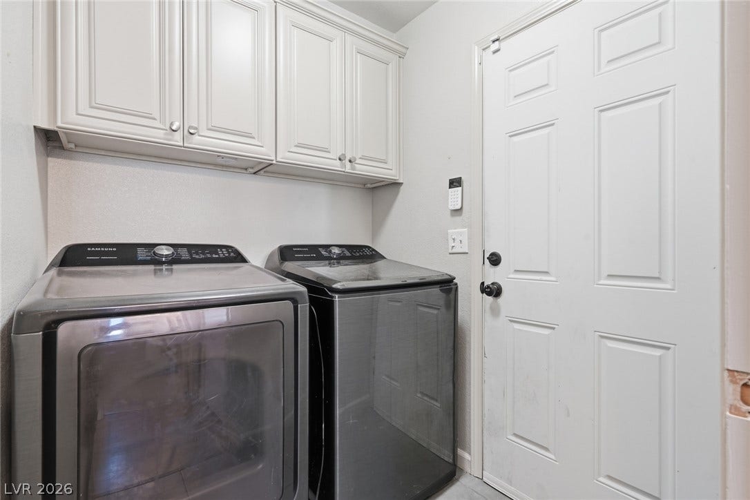 206 Oleander Place, Henderson, NV 89015 Functional laundry space featuring modern appliances and upper cabinetry for organized storage.