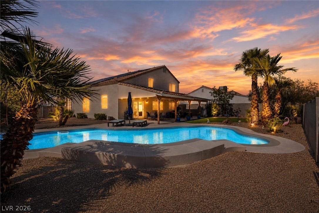 206 Oleander Place, Henderson, NV 89015 An inviting backyard oasis features a glistening pool and covered patio, perfect for evening gatherings under a vibrant sunset.