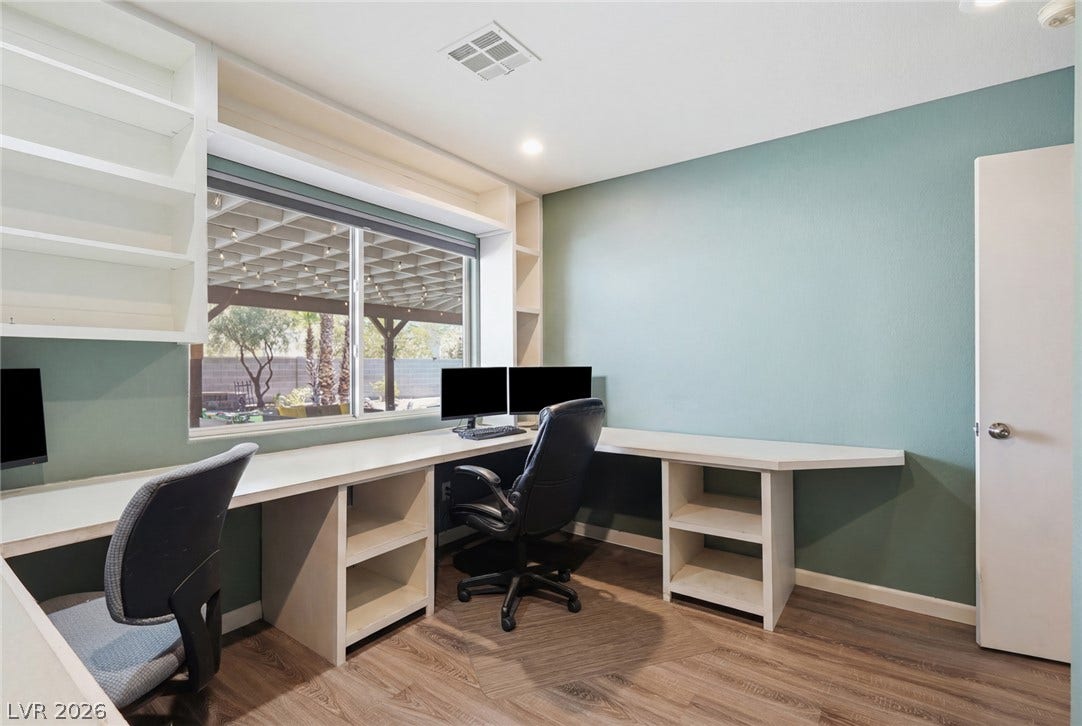 206 Oleander Place, Henderson, NV 89015 A dedicated home office space with built-in shelving provides abundant natural illumination and a backyard view.