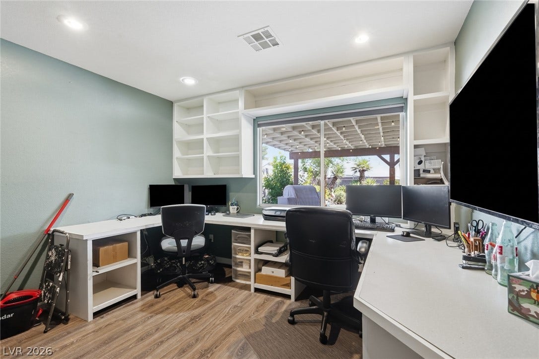 206 Oleander Place, Henderson, NV 89015 Built-in shelving and desks create a functional home office space with outdoor access.