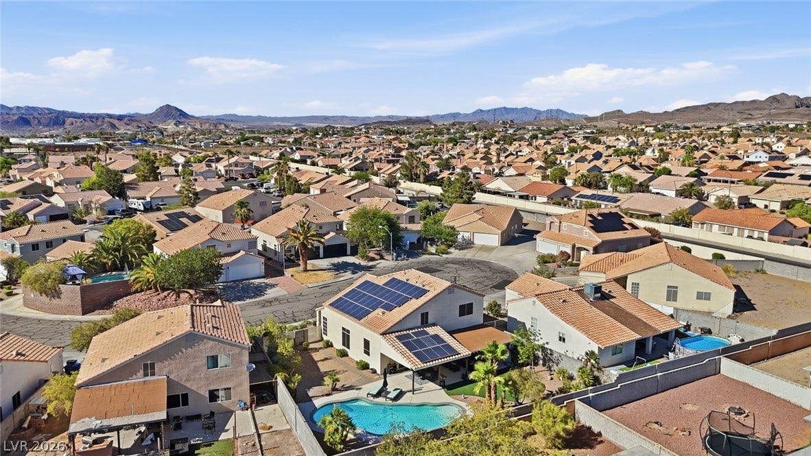 206 Oleander Place, Henderson, NV 89015 An aerial perspective reveals a vibrant neighborhood with individual pools, nestled against a mountainous backdrop.