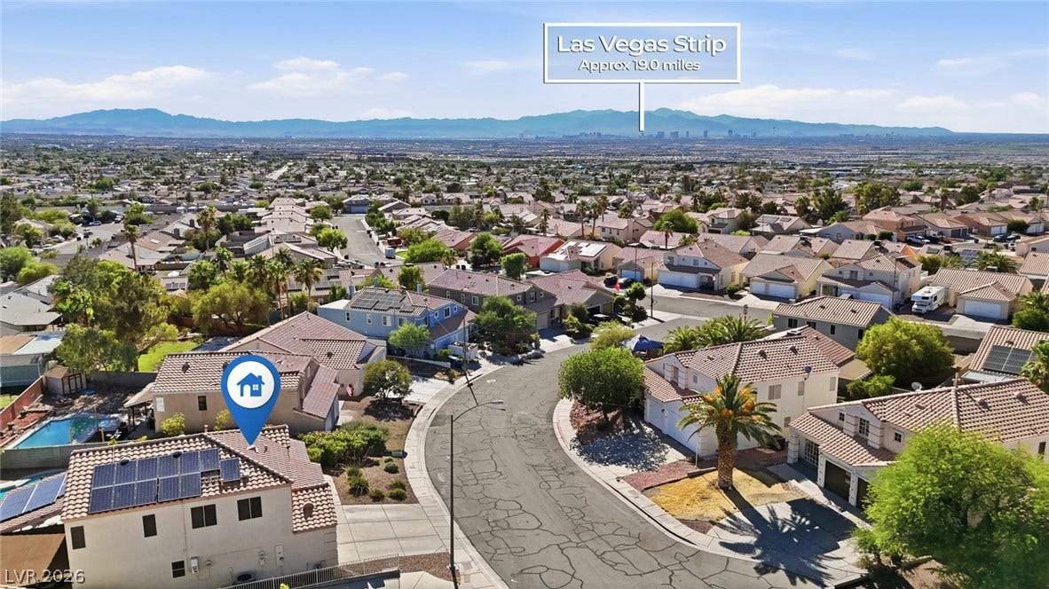 206 Oleander Place, Henderson, NV 89015 An aerial perspective reveals a residential community with distant mountain and city skyline views.