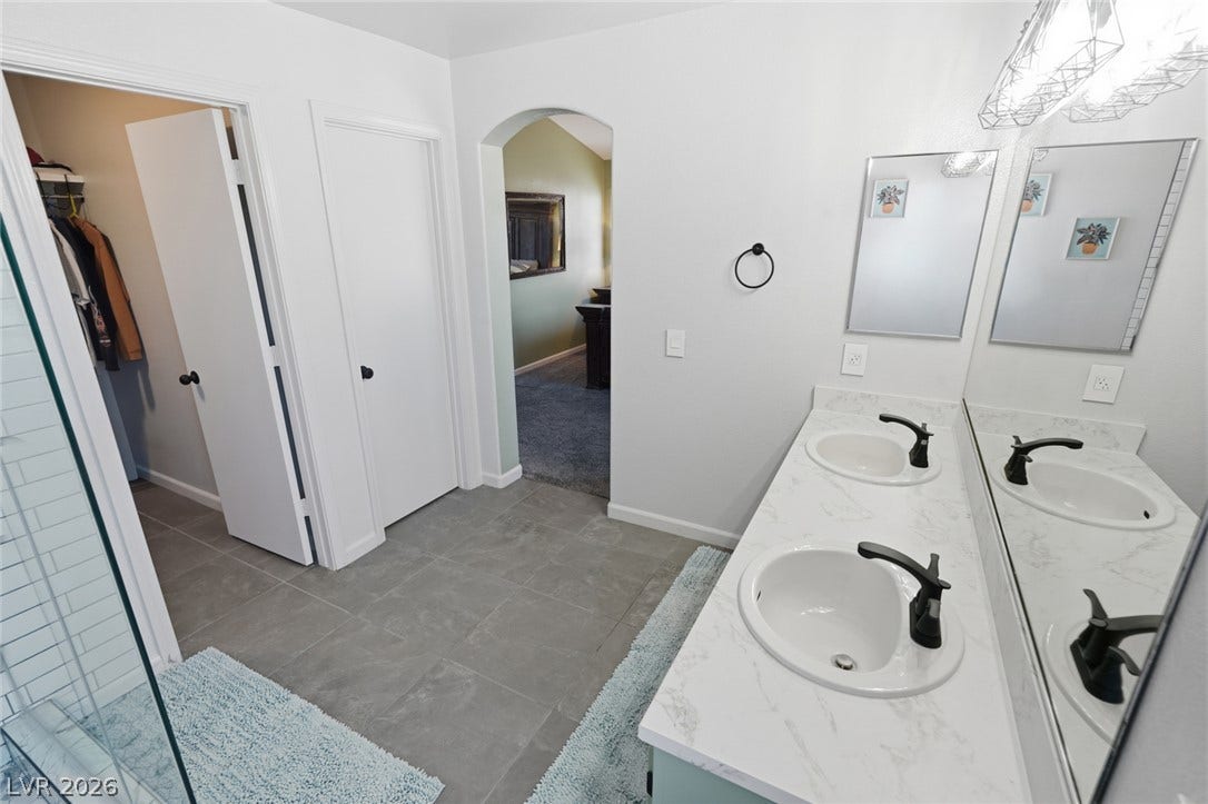 206 Oleander Place, Henderson, NV 89015 Double vanities and contemporary fixtures enhance this primary bathroom's functionality.