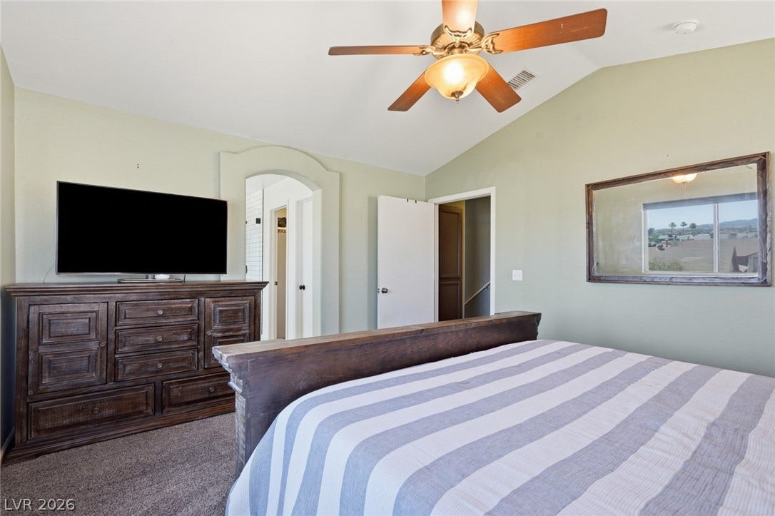 206 Oleander Place, Henderson, NV 89015 A comfortable bedroom with a vaulted ceiling and functional ceiling fan.