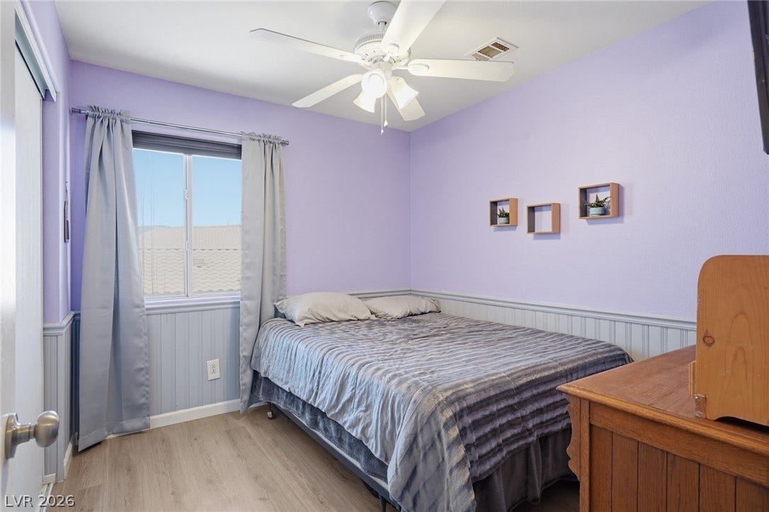 206 Oleander Place, Henderson, NV 89015 A well-lit room showcases durable laminate flooring, a ceiling fan, and a wide window offering a distant view.