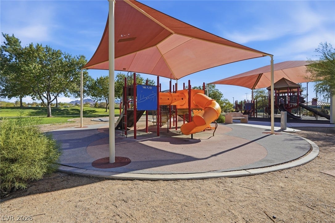 206 Oleander Place, Henderson, NV 89015 A well-maintained community playground offers endless fun under shade structures, surrounded by green spaces and distant mountains.