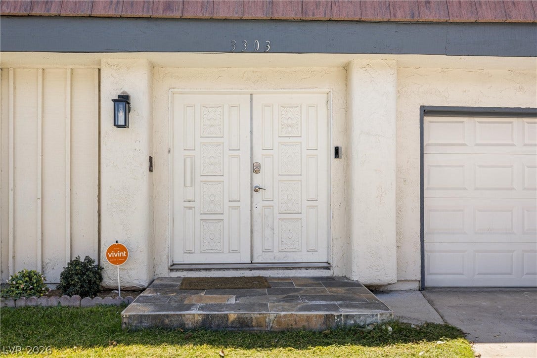 3303 Royce Court, Las Vegas, NV 89121 A welcoming entry features stately double doors and a practical garage.