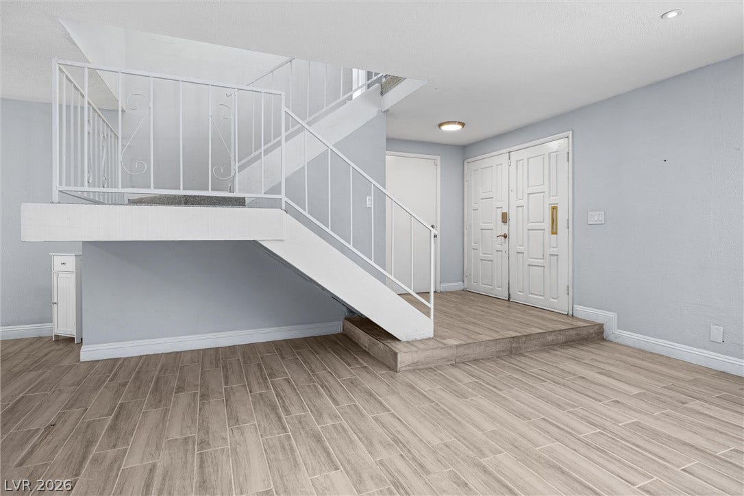 3303 Royce Court, Las Vegas, NV 89121 An inviting entry showcases a grand staircase and durable wood-look tile flooring.