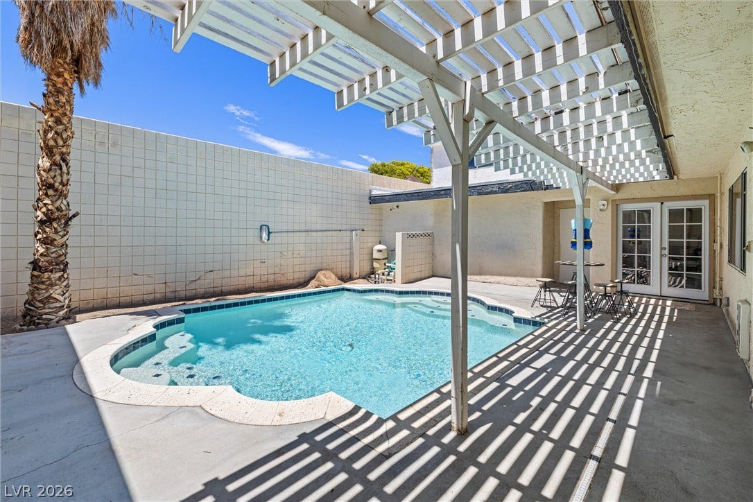 3303 Royce Court, Las Vegas, NV 89121 A tranquil private pool area, perfect for sun-drenched relaxation, featuring a shaded patio and direct indoor access.