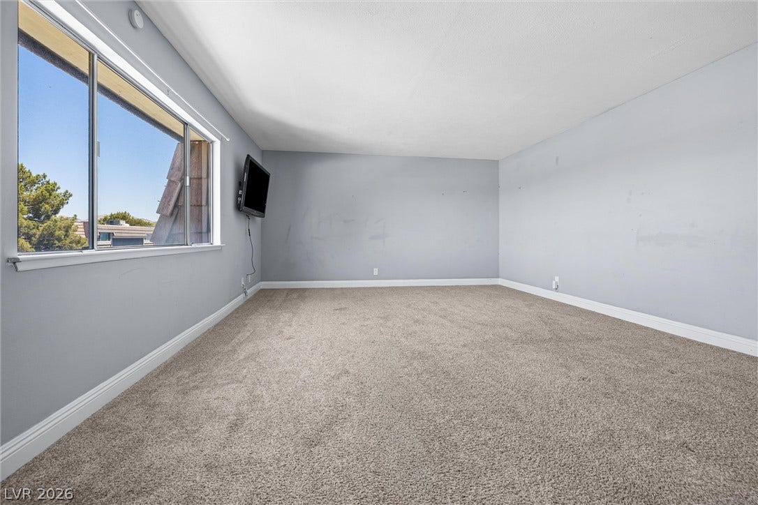 3303 Royce Court, Las Vegas, NV 89121 An airy interior space featuring soft carpet and a large window inviting natural light.