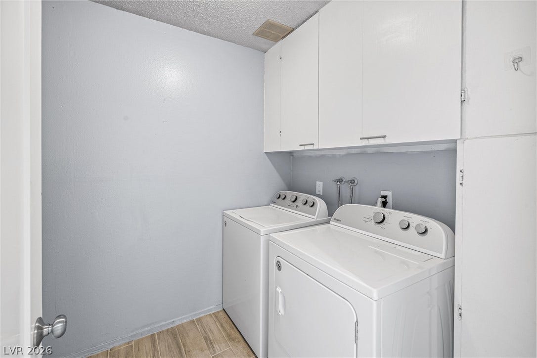3303 Royce Court, Las Vegas, NV 89121 Functional laundry space featuring convenient upper cabinetry and essential appliances.