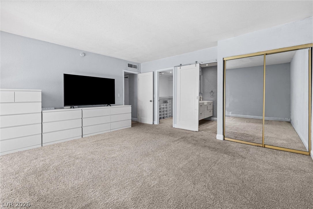 3303 Royce Court, Las Vegas, NV 89121 A spacious bedroom provides a comfortable retreat with plush carpet and easy access to a private bathroom and closet.