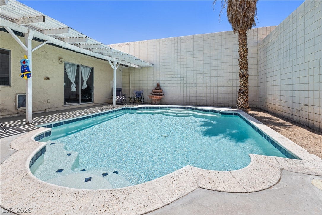 3303 Royce Court, Las Vegas, NV 89121 A private backyard oasis features an inviting in-ground pool with elegant stone coping.