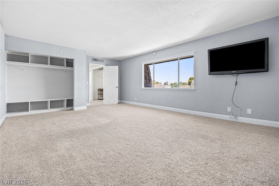 3303 Royce Court, Las Vegas, NV 89121 An airy bedroom with soft carpet, ample storage, and abundant natural light.