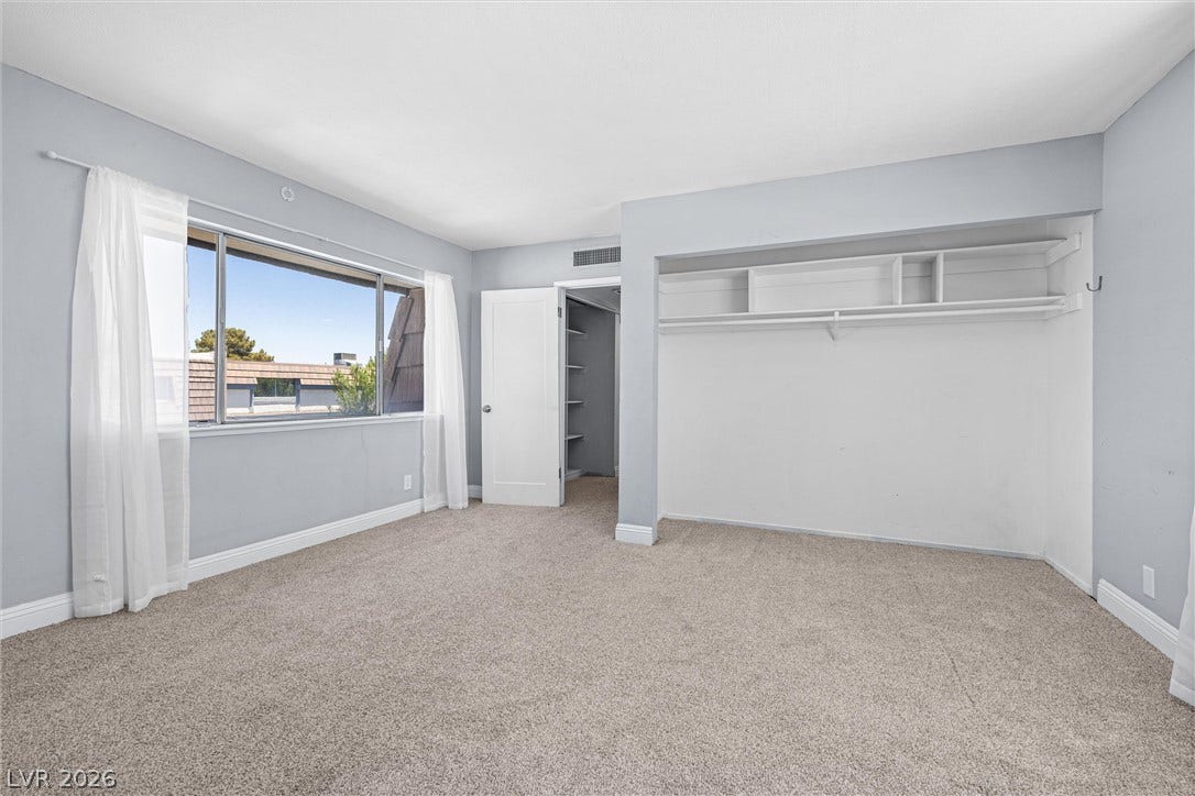 3303 Royce Court, Las Vegas, NV 89121 A spacious bedroom features a large window offering neighborhood views and a convenient built-in closet system.