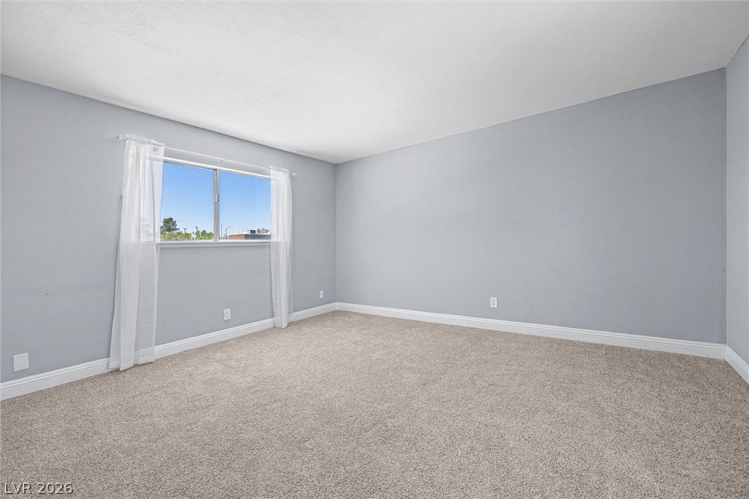 3303 Royce Court, Las Vegas, NV 89121 A spacious room offers ample natural light and plush carpet flooring.