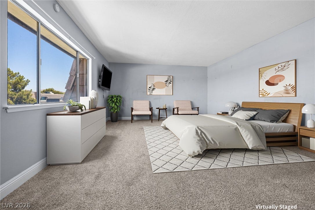 3303 Royce Court, Las Vegas, NV 89121 A well-lit bedroom features plush carpeting and a wide window offering urban neighborhood views.