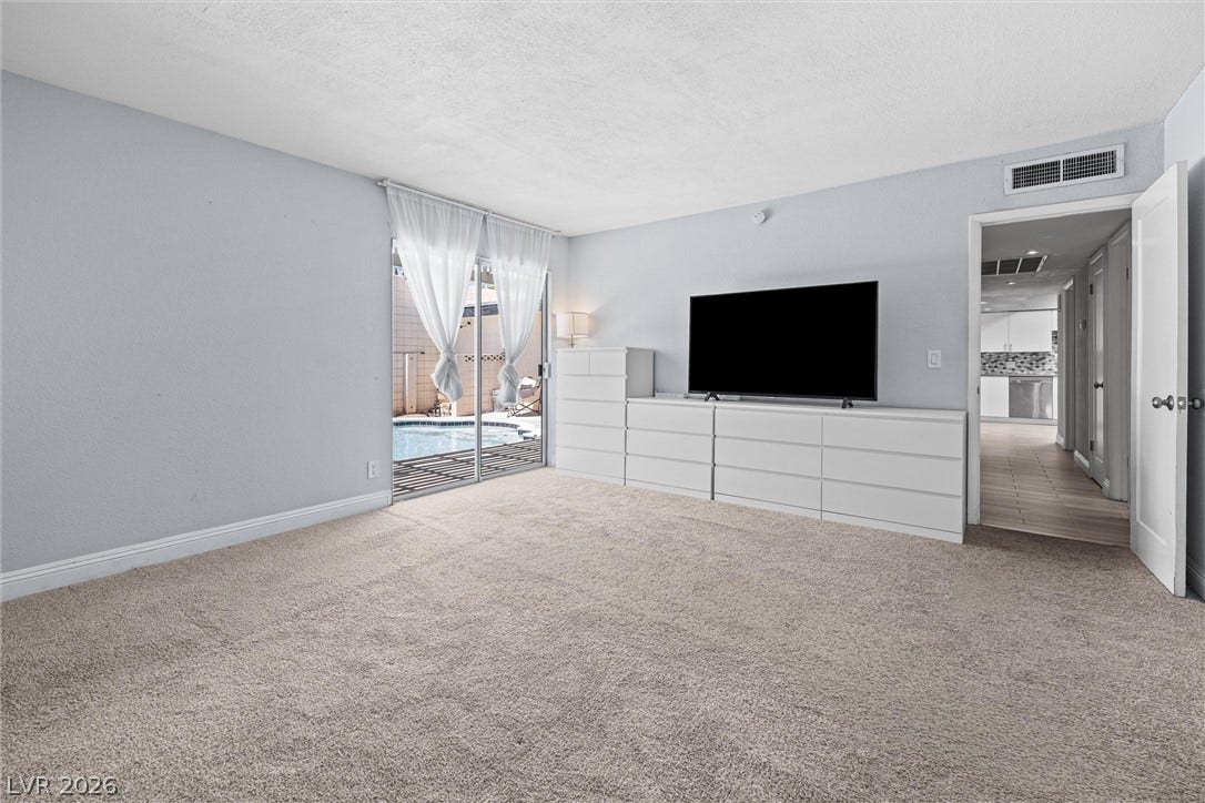 3303 Royce Court, Las Vegas, NV 89121 Sliding glass doors offer poolside access from this comfortable, carpeted living space.