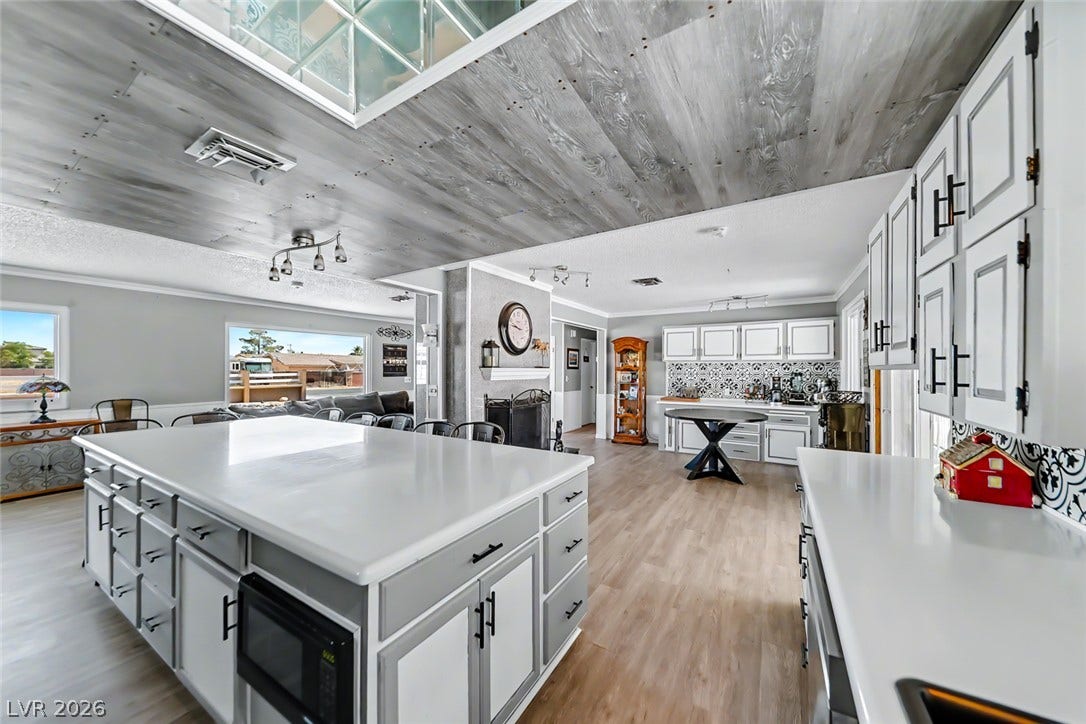 A spacious kitchen with an inviting island and a distinctive decorative ceiling.