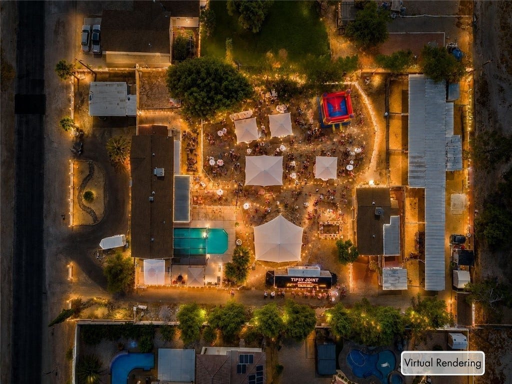 An aerial perspective captures the expansive backyard venue layout illuminated by festive string lights.
