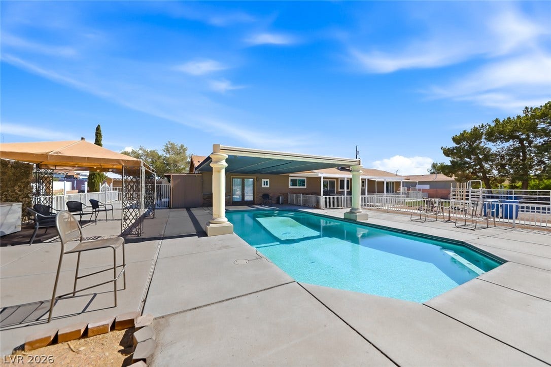 An inviting backyard oasis awaits with a sparkling inground pool and spacious patio for entertaining.