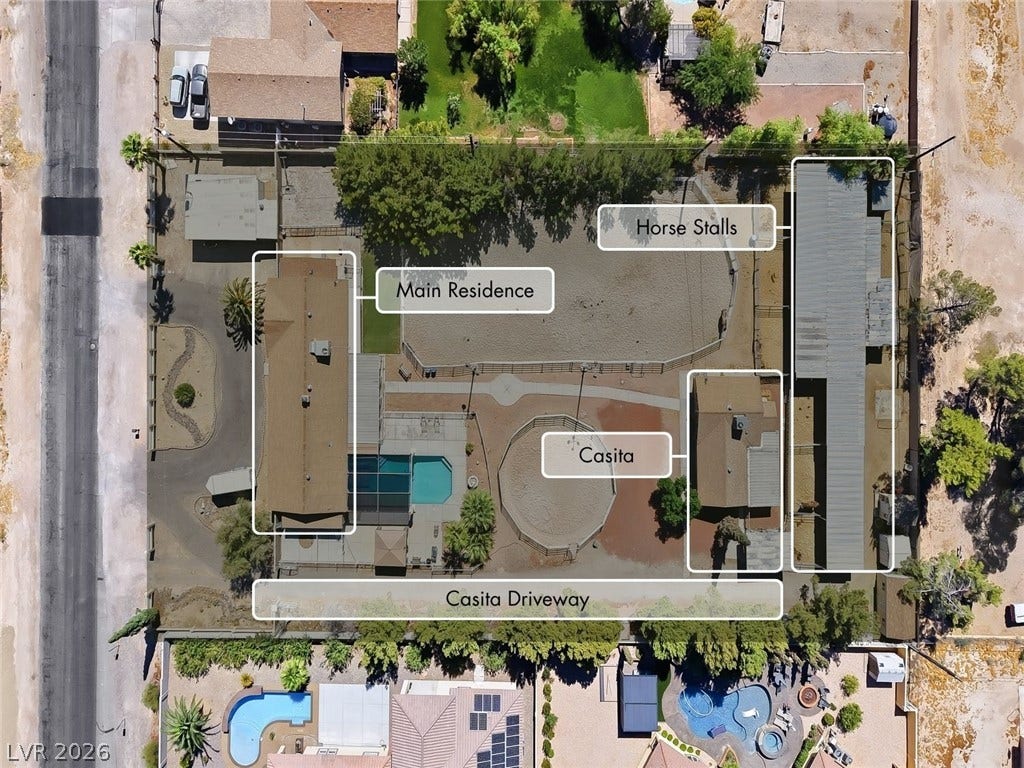 An aerial perspective showcases the entire property layout including the main home, pool, and equestrian facilities.