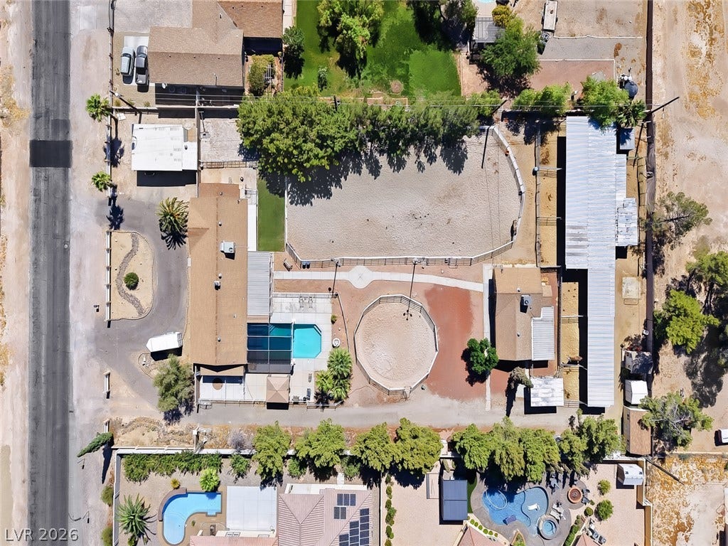 An aerial perspective reveals a private pool, equestrian facilities, horseshoe driveway, and ample outdoor space.