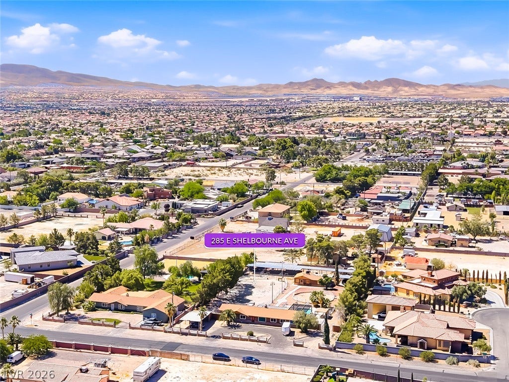 An aerial perspective showcases the neighborhood's expansive landscape with mountains gracing the horizon.