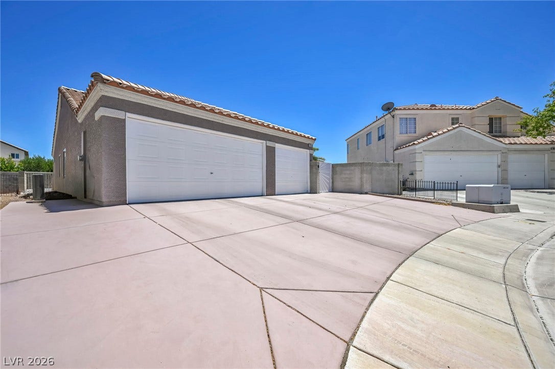 A spacious driveway and multi-car garages offer ample parking and utility.