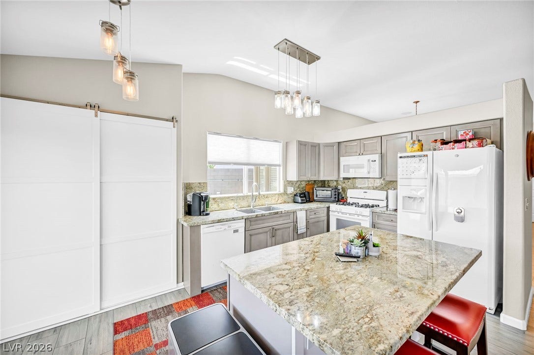 Culinary delights await in this bright kitchen, showcasing a spacious island with ample counter space.