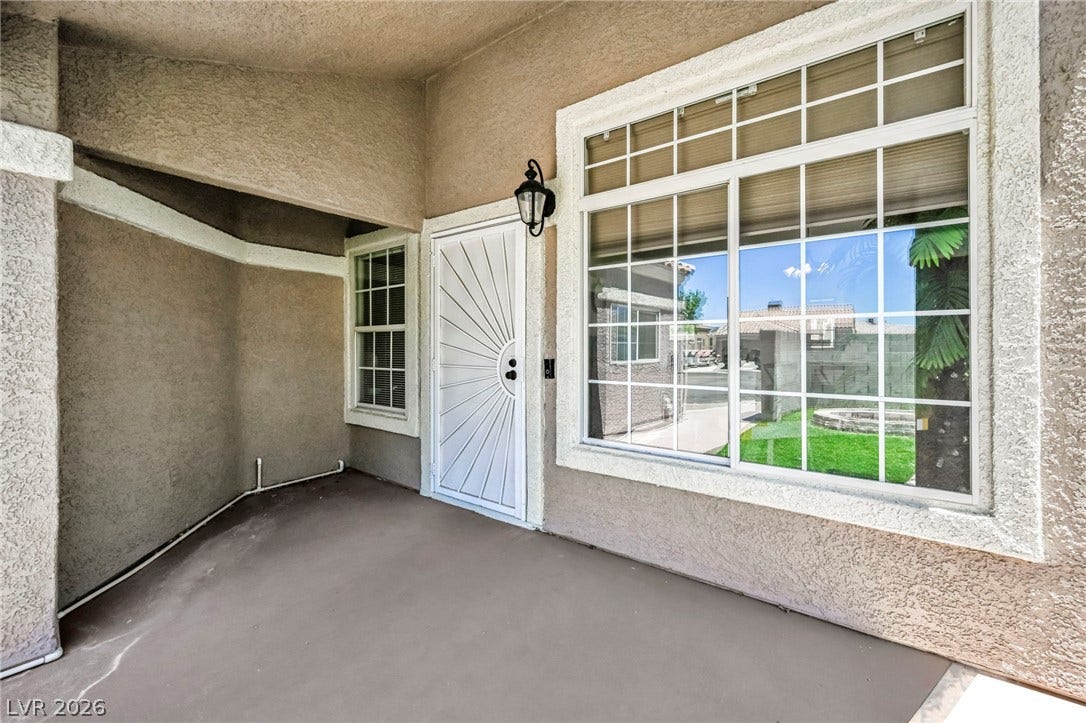 A welcoming covered patio provides a shaded entry with views of the outdoor space.