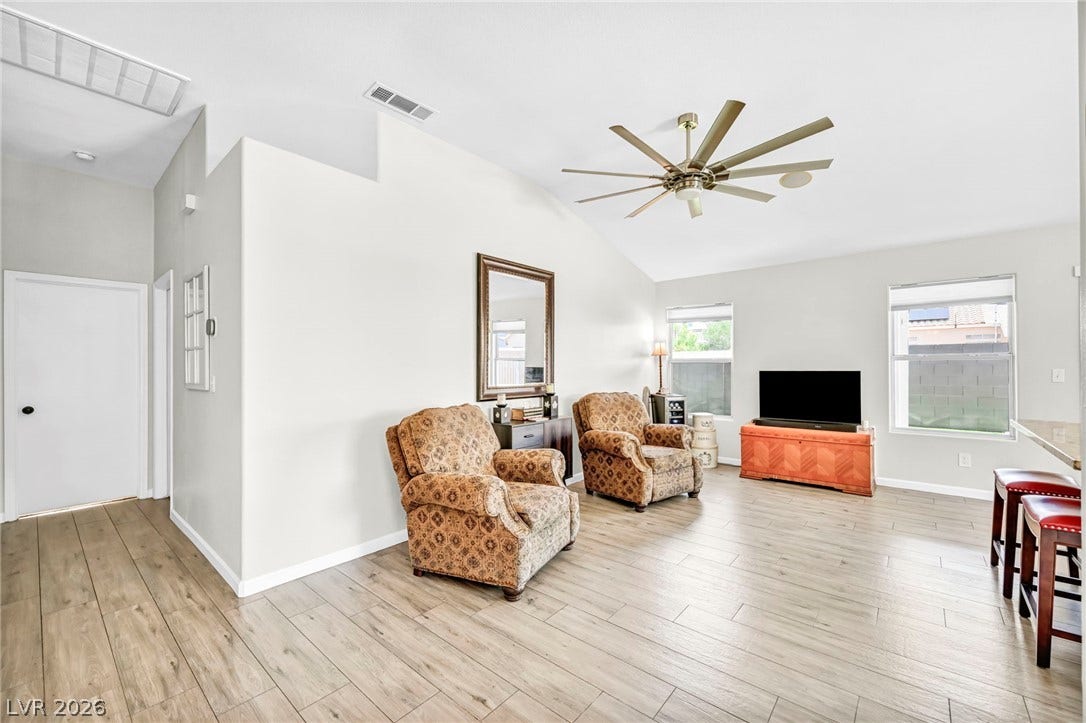 A relaxed living area with light wood-look flooring and soaring vaulted ceilings.