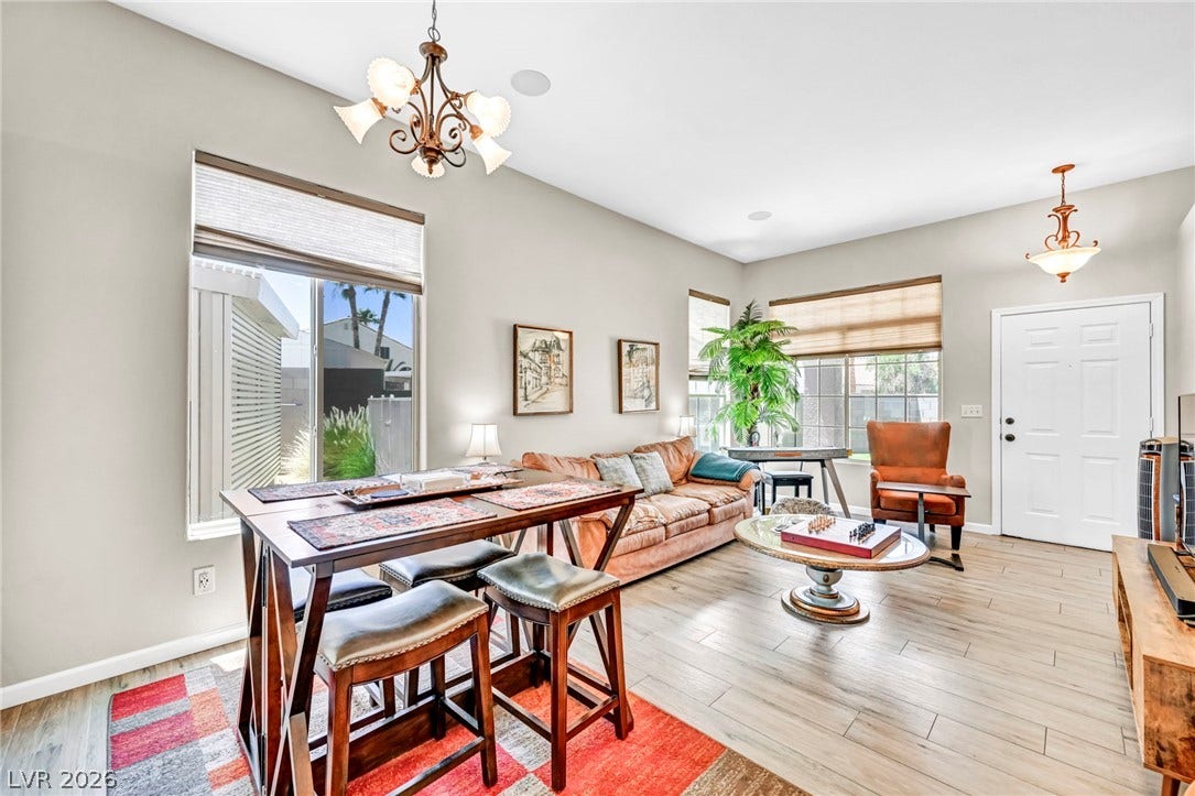 Natural light illuminates this inviting living space with high ceilings and wood-look flooring.